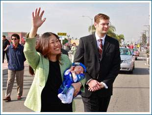 Janet Nguyen carries her kid like a football at the Tet Parade