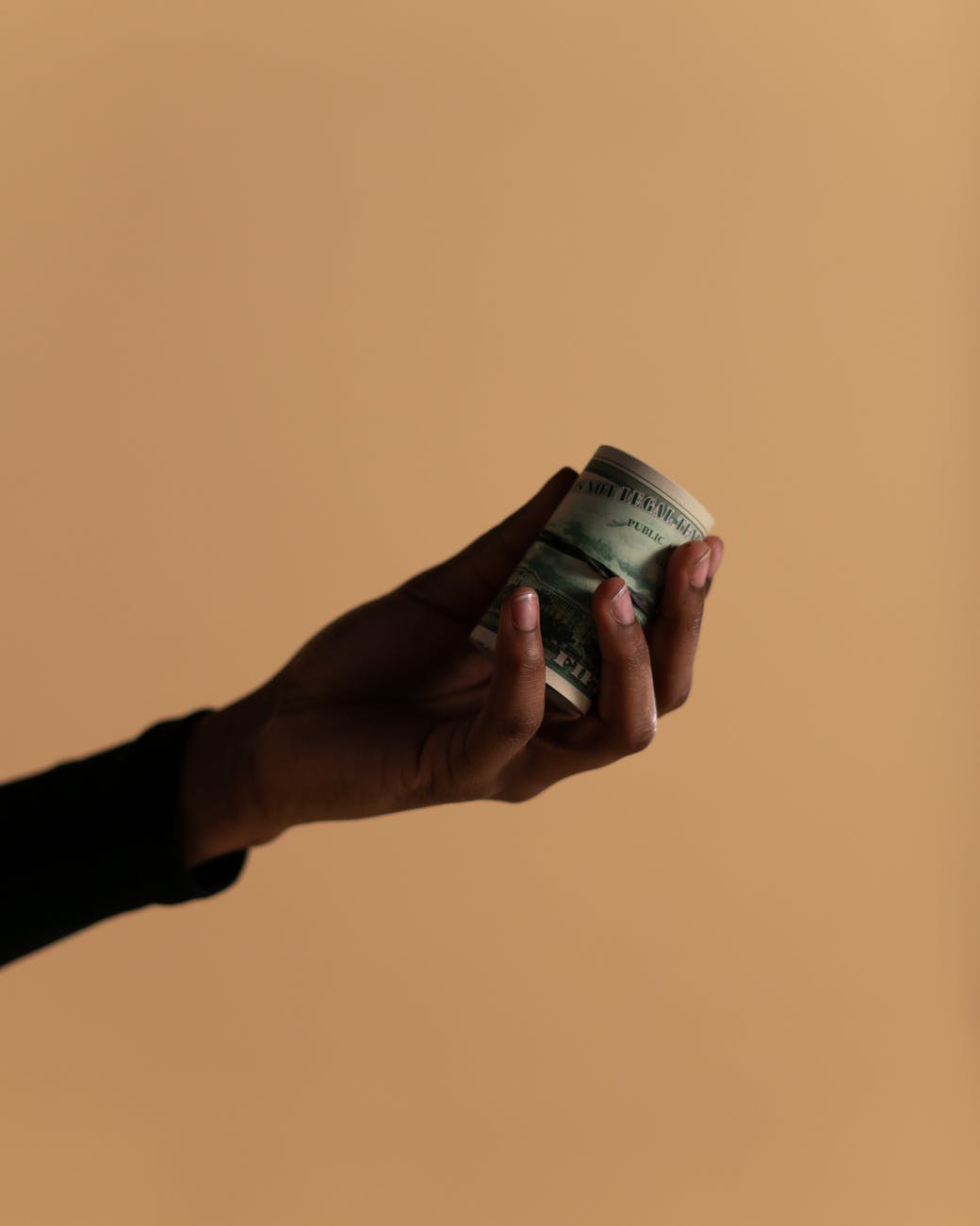 person holding rolled banknotes