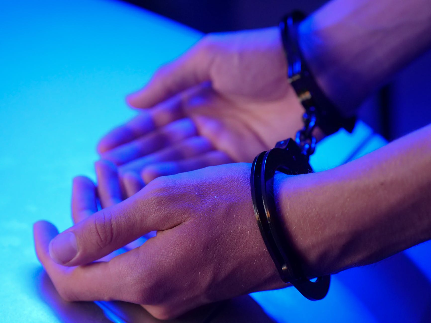 person wearing metal handcuffs